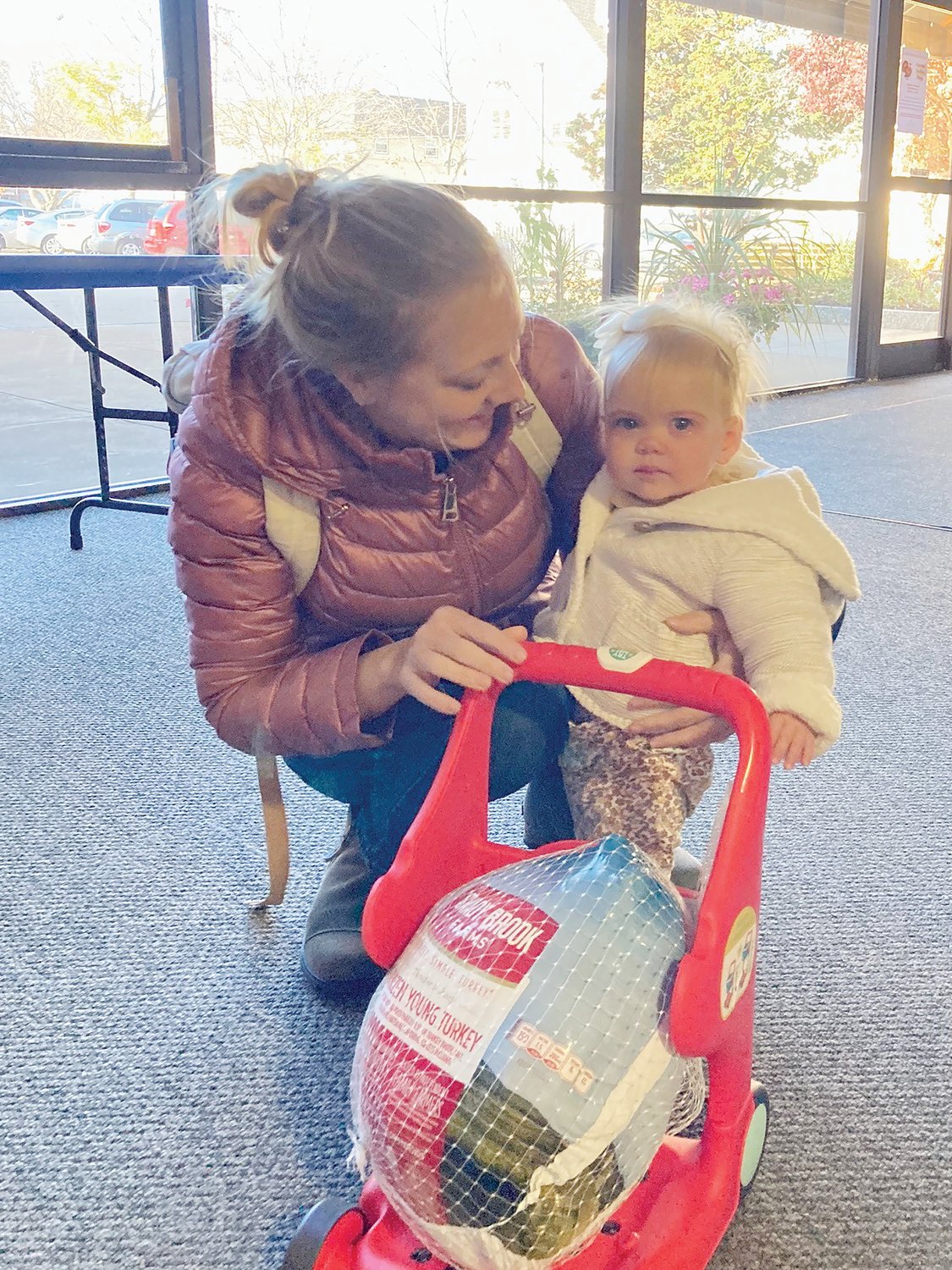 Throughout the November collection, friends and neighbors stopped by the residence with a turkey or two. One turkey was recently delivered by the tiniest of donors — a one-year-old who rolled it into the Home with her own cart, above.